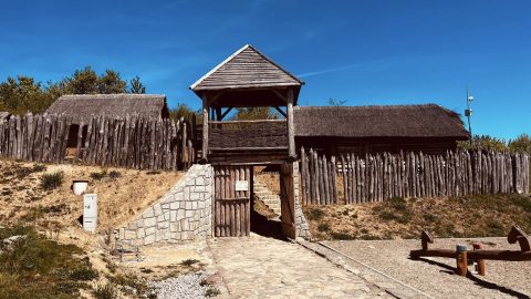 Šuhajovci na cestách: historická brána a drevená opona v archeoparku.