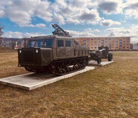 Historická vojenská technika na výstave v parku, vojenský tank a vozidlo na cestách.