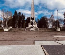 Pamätník na námestí s výhľadom na oblohu a okolitú zeleň.