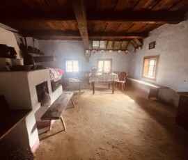 Historická kuchyňa s dreveným stropom a rustikálnym zariadením.