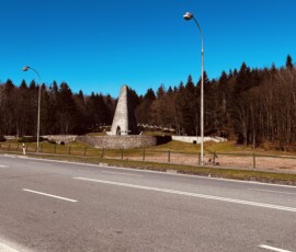 Cesta v Šuhajovcoch s výhľadom na pamätník a okolitú prírodu.