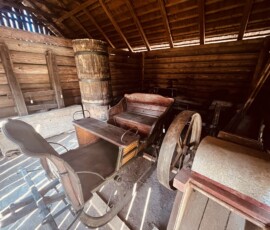 Historický kočiar v drevenej stodole, tradičné remeslo a história Slovenska.